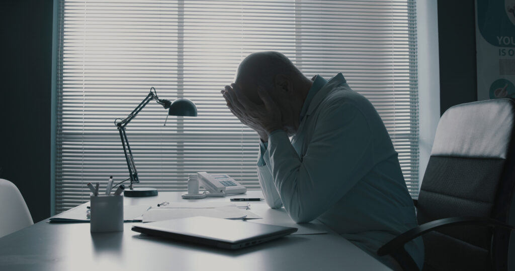 Stressed worker at desk suffering from burnout.